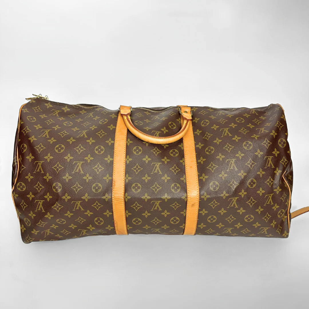 Brown travel bag with yellow handles on a light gray background