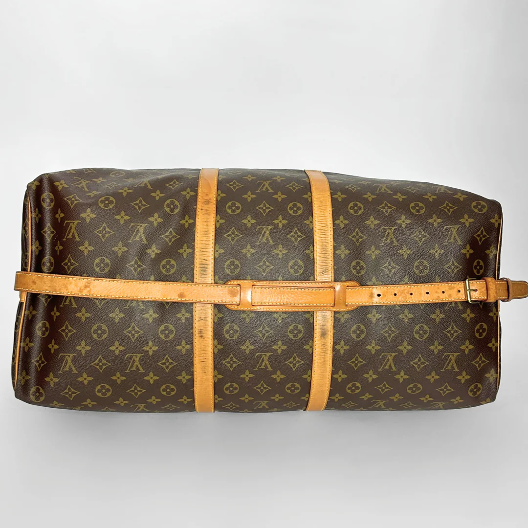 Louis Vuitton monogram duffel bag with brown leather straps on a light gray background