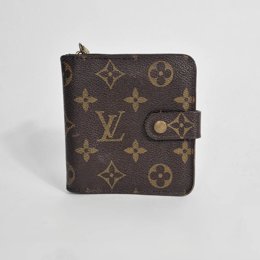 Louis Vuitton wallet with monogram pattern on a light gray background