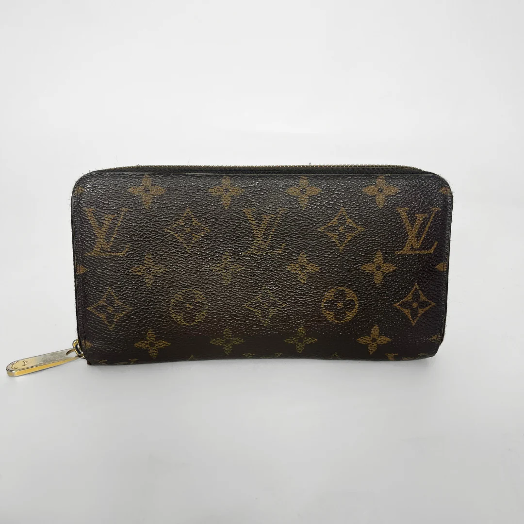 Louis Vuitton wallet with monogram pattern on a white background
