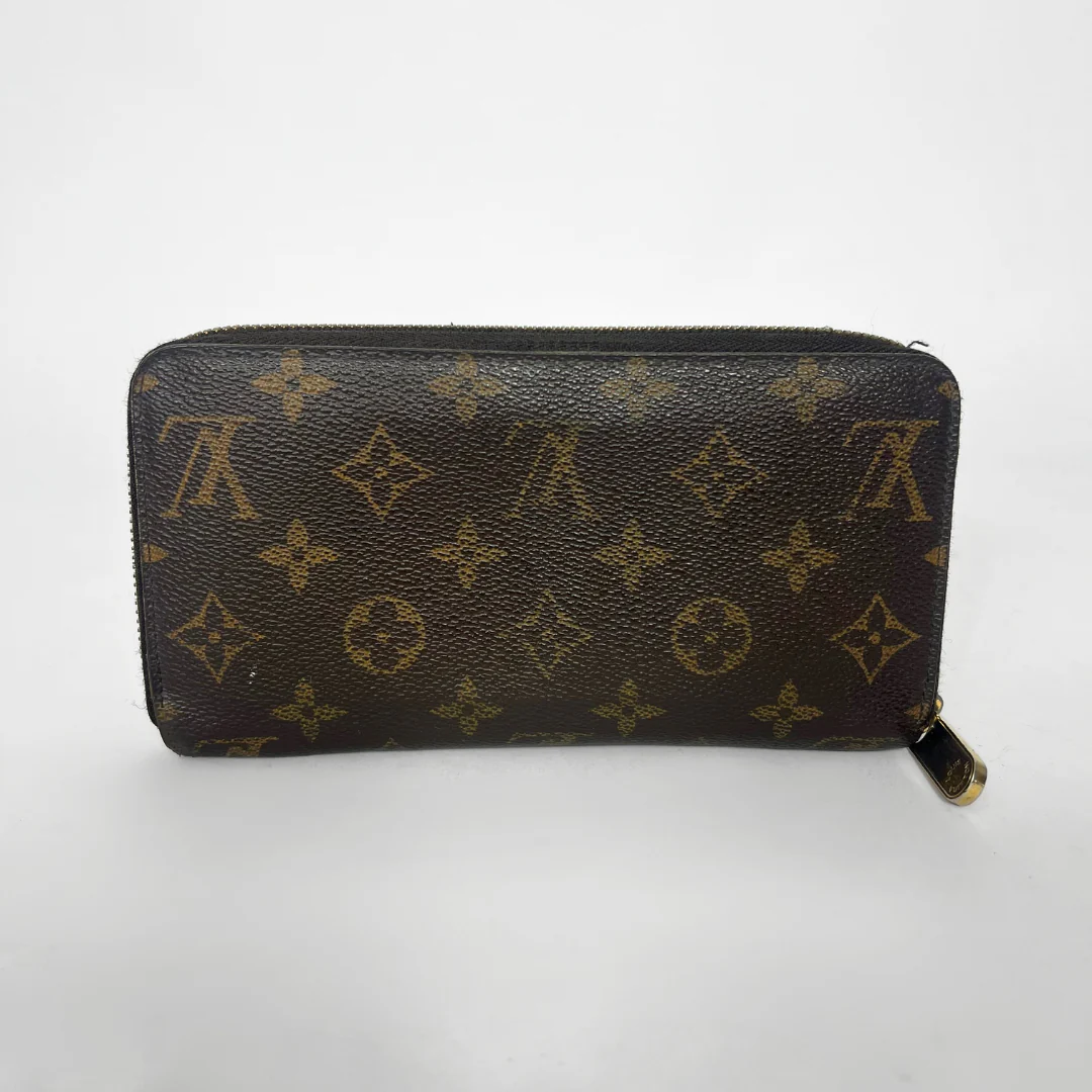 Louis Vuitton wallet with monogram pattern on a white background