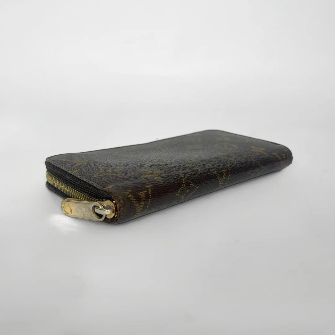 Designer wallet with monogram pattern on a light gray background