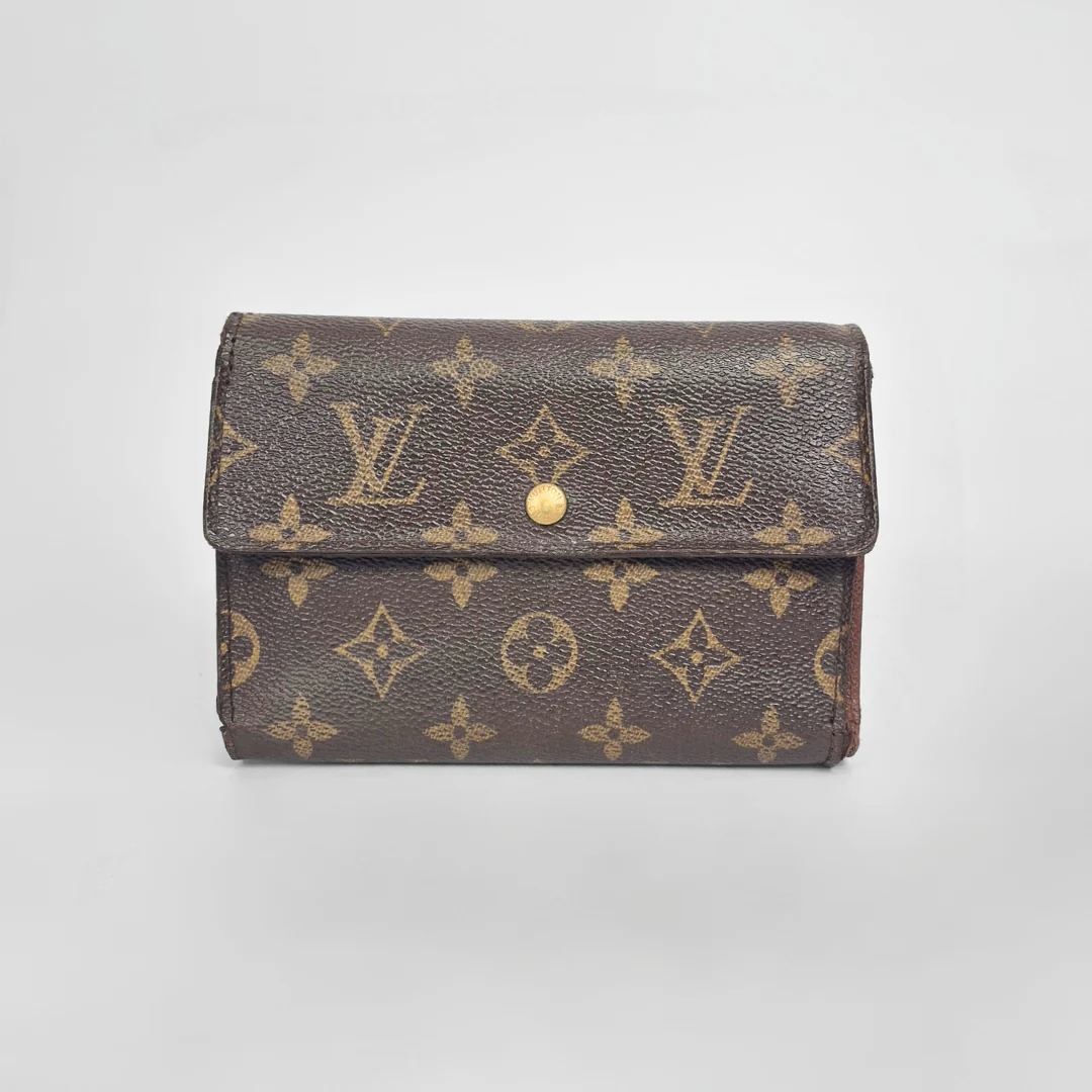 Louis Vuitton wallet with monogram pattern on a light gray background