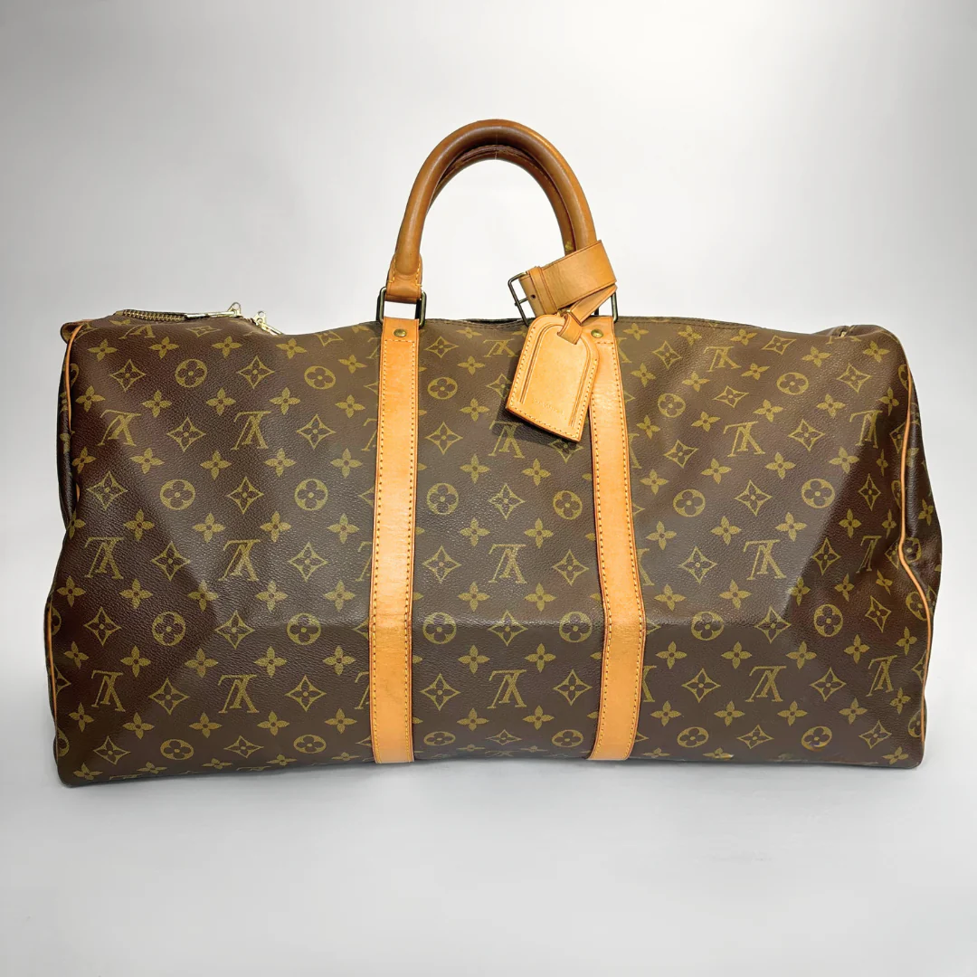 Brown travel bag with yellow monogram pattern on a white background