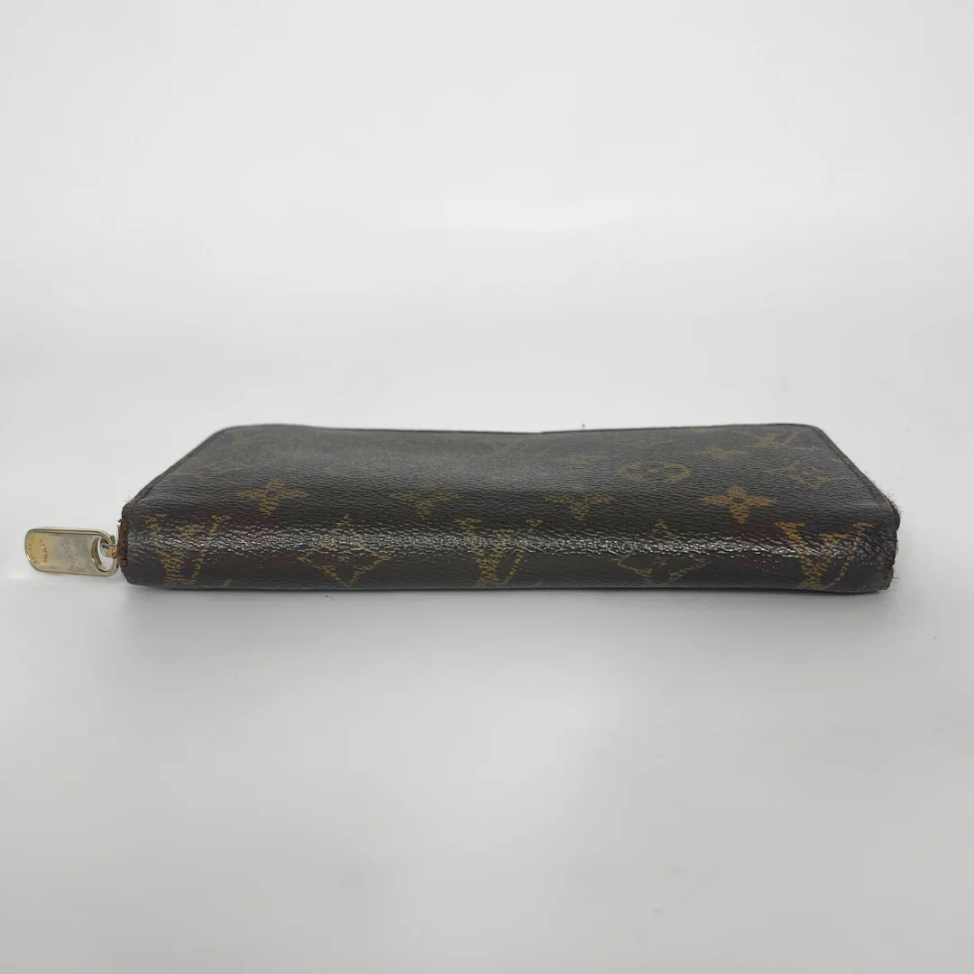 Louis Vuitton wallet with monogram pattern on a white background