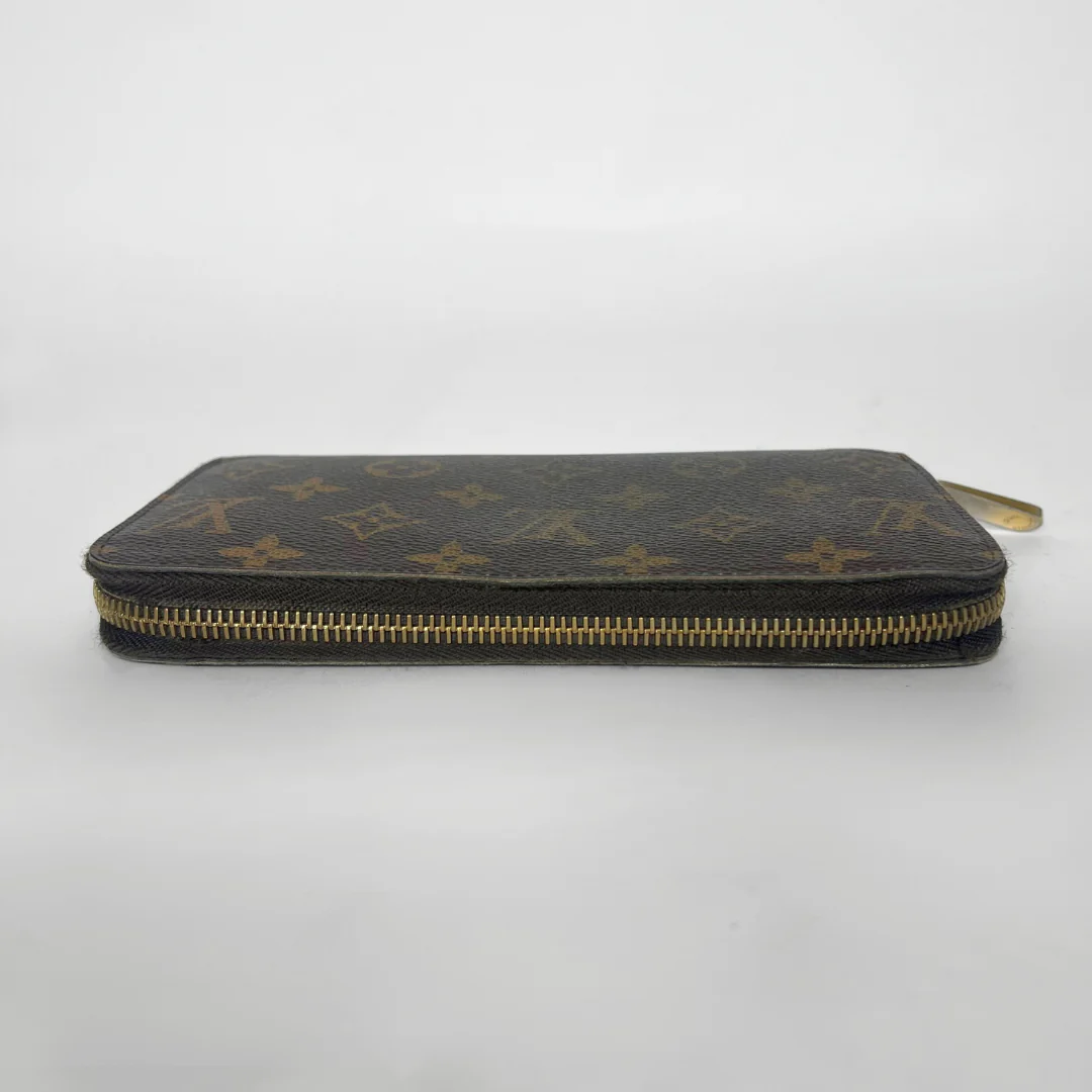 Louis Vuitton wallet with monogram pattern on a white background