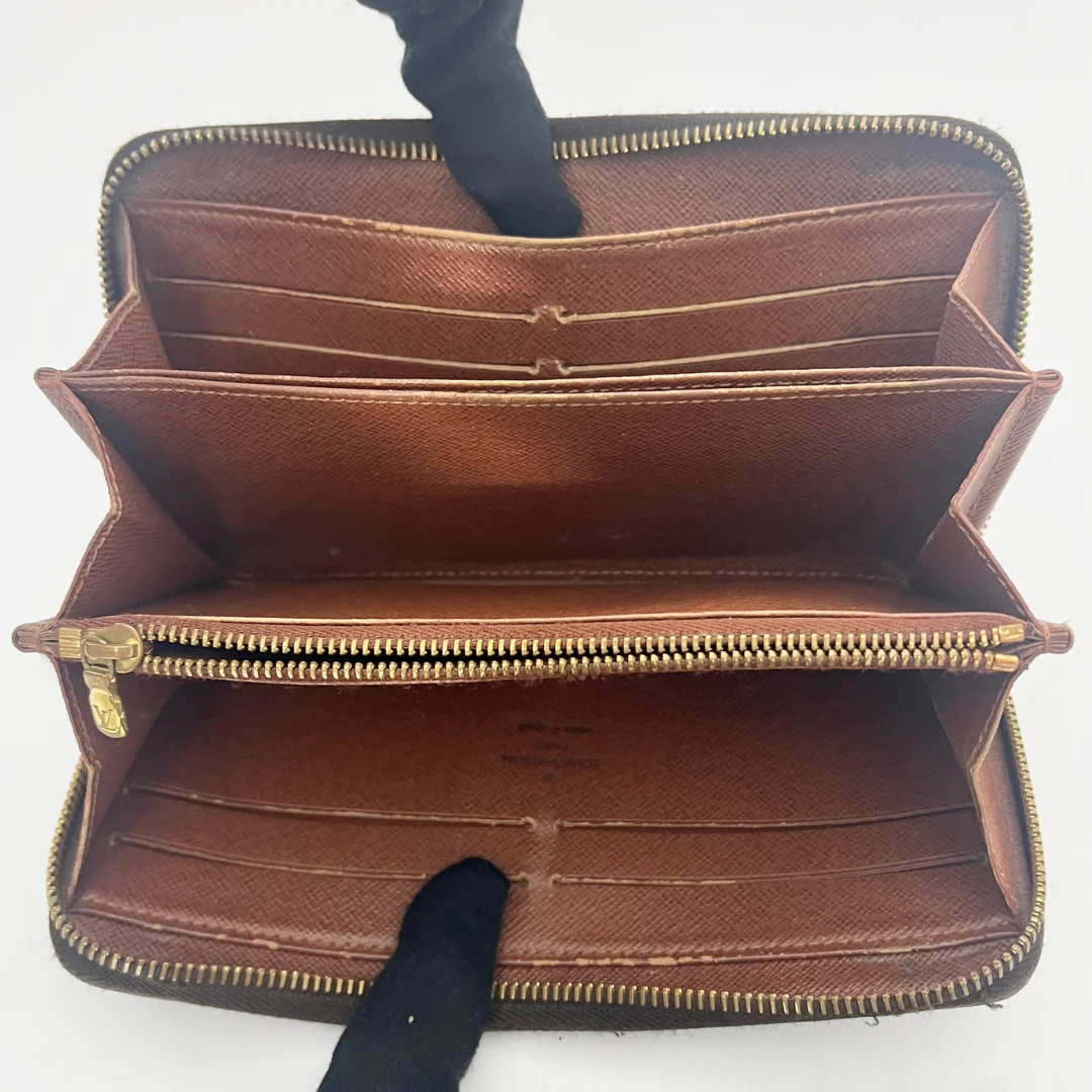 Brown leather wallet with gold zipper on a white background