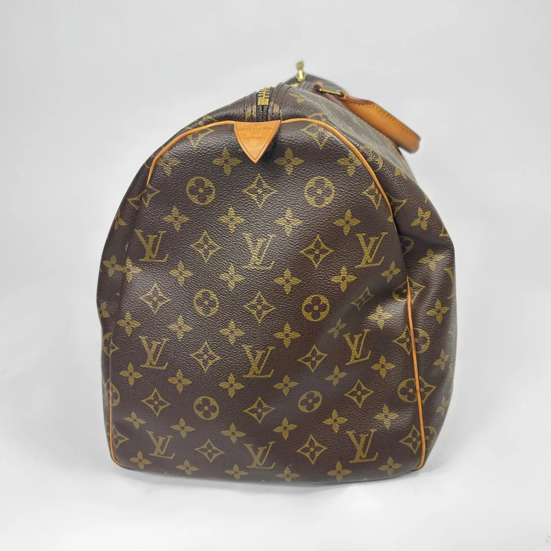 Brown travel bag with tan straps on a white background