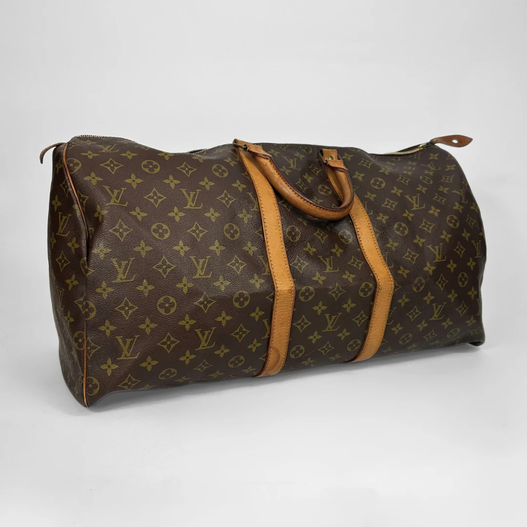 Brown travel bag with tan handles and trim on a white background