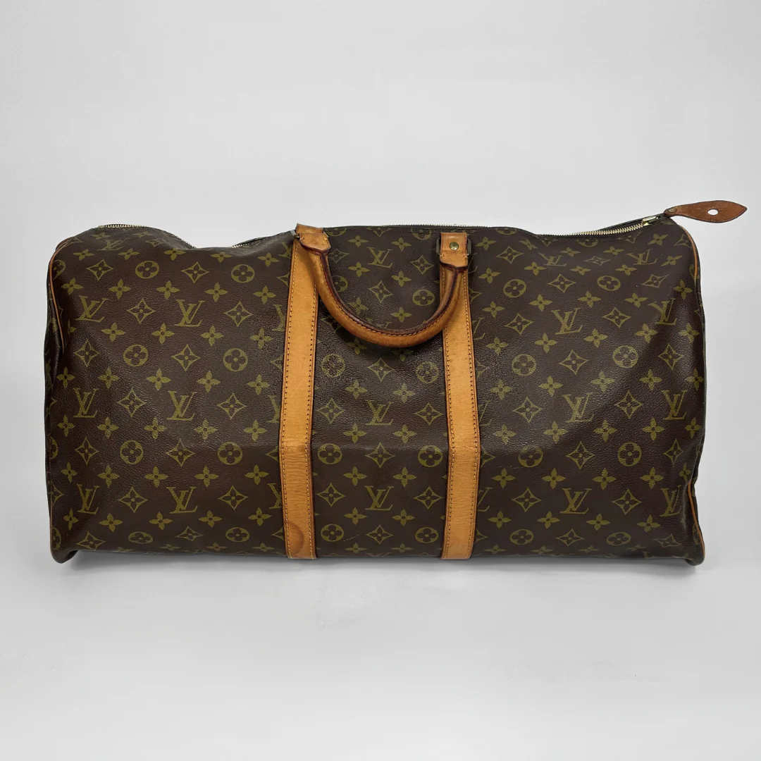 Brown travel bag with tan leather straps on a white background