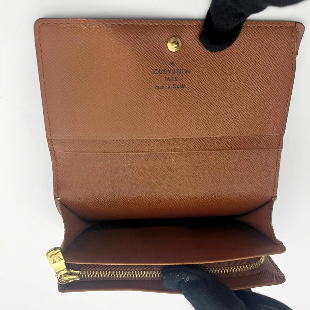 Folded wallet with brown leather interior on a white background