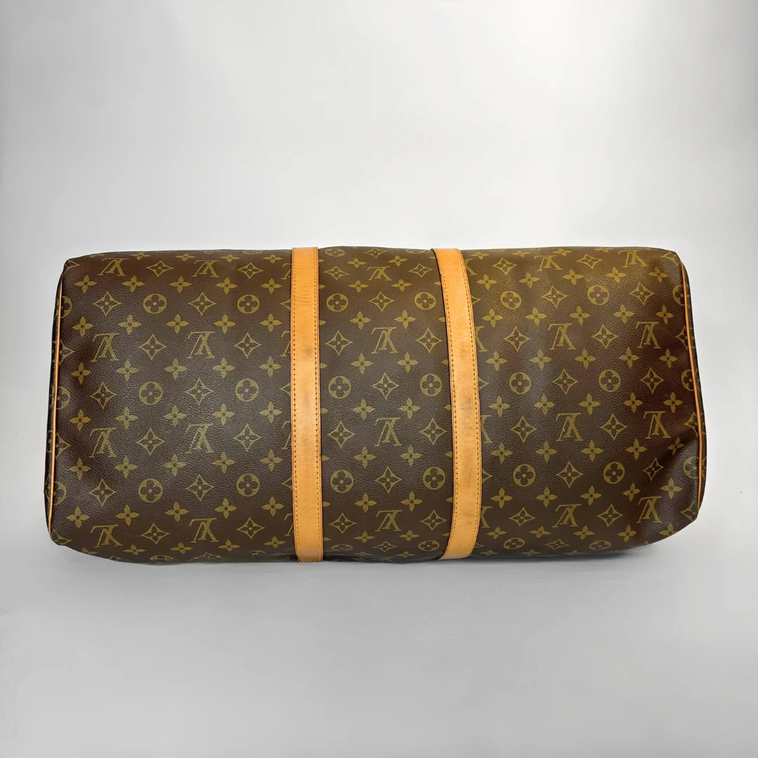 Brown patterned travel bag with orange straps on a light gray background