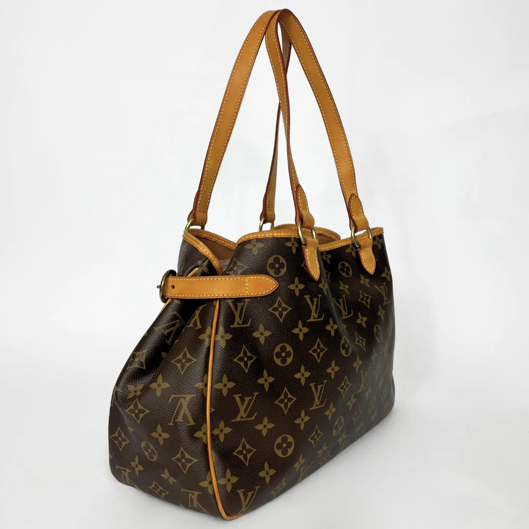 Brown handbag with tan leather straps on a white background