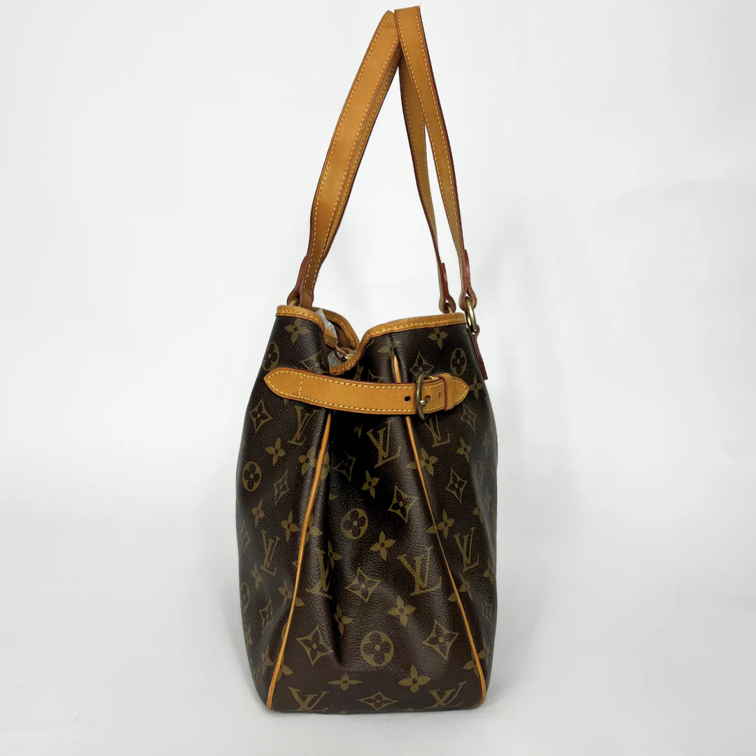 Brown monogram handbag with tan leather handle on a white background