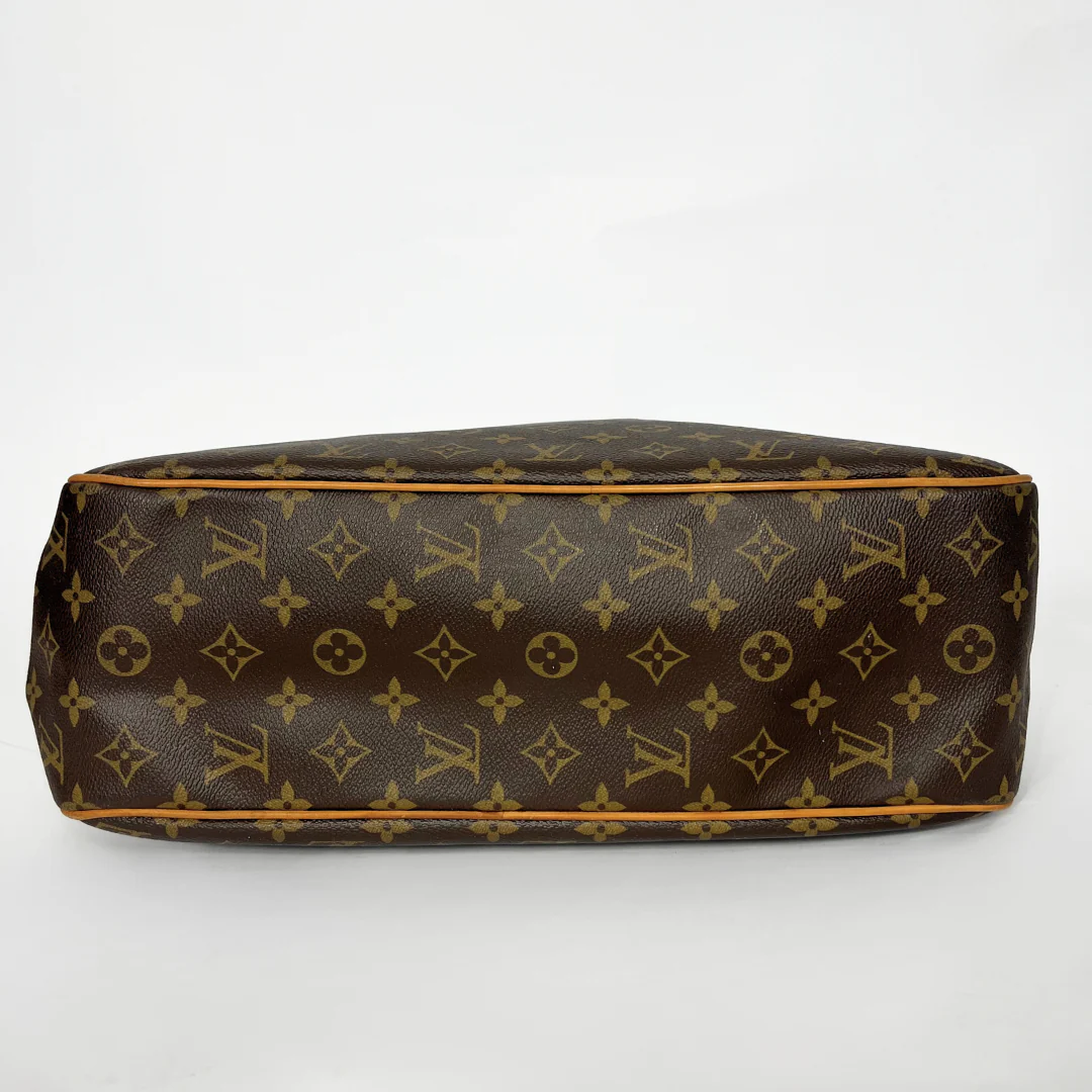 Brown handbag with gold monogram pattern on a white background