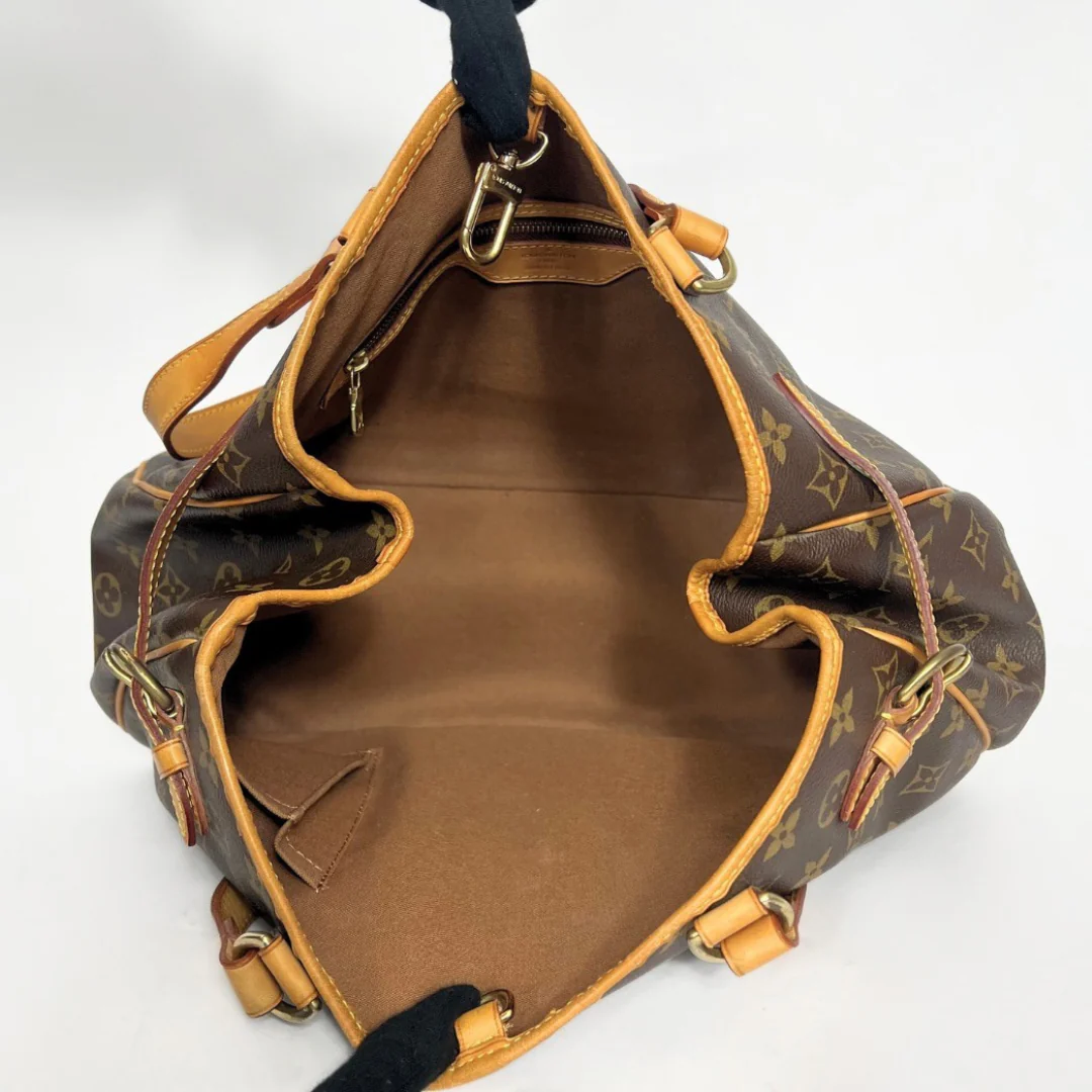 Brown leather handbag with gold accents on a white background