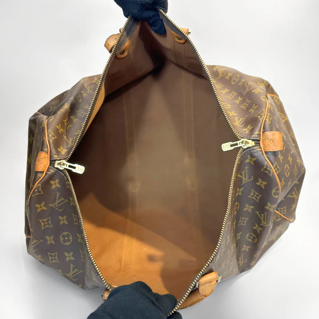 Louis Vuitton monogram bag with open zipper on a white background