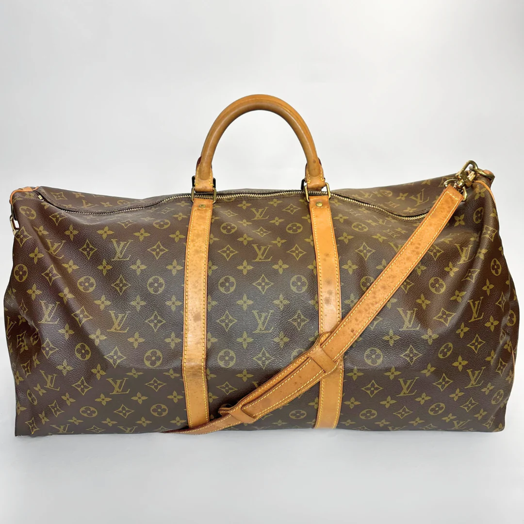 Brown travel bag with tan leather straps on a white background