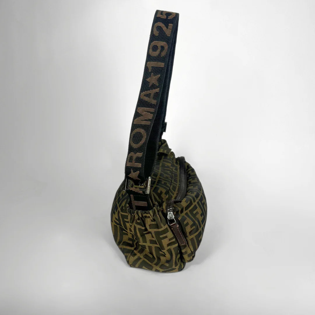 Green patterned bag with a black strap on a white background