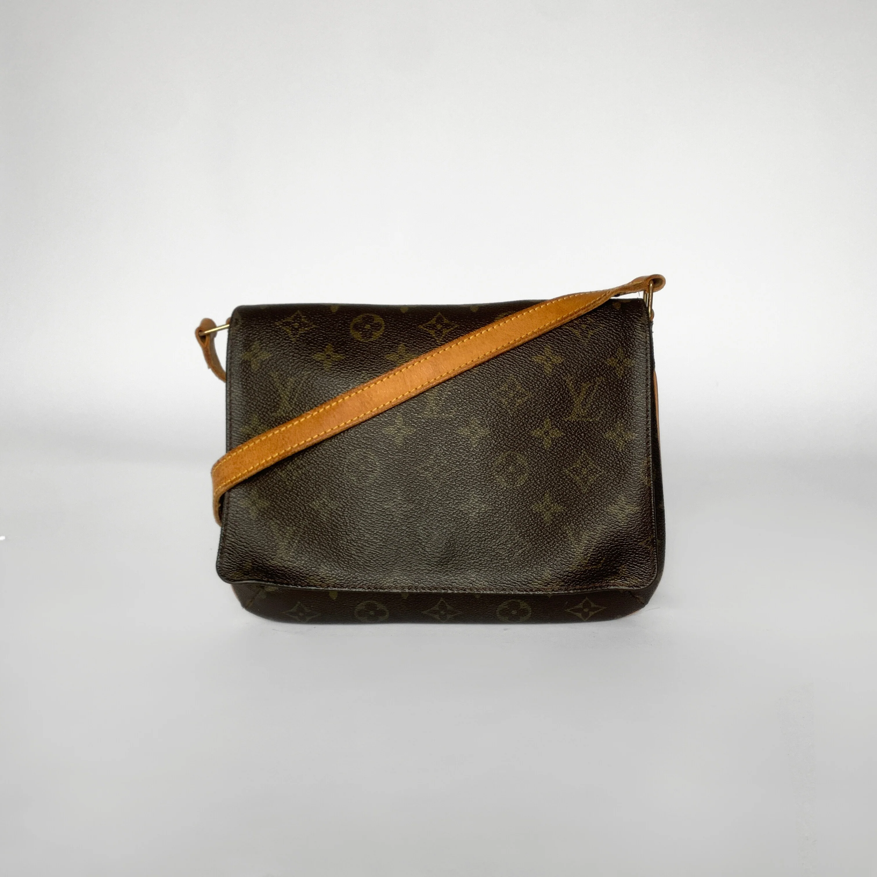Designer handbag with monogram pattern and brown strap on a white background