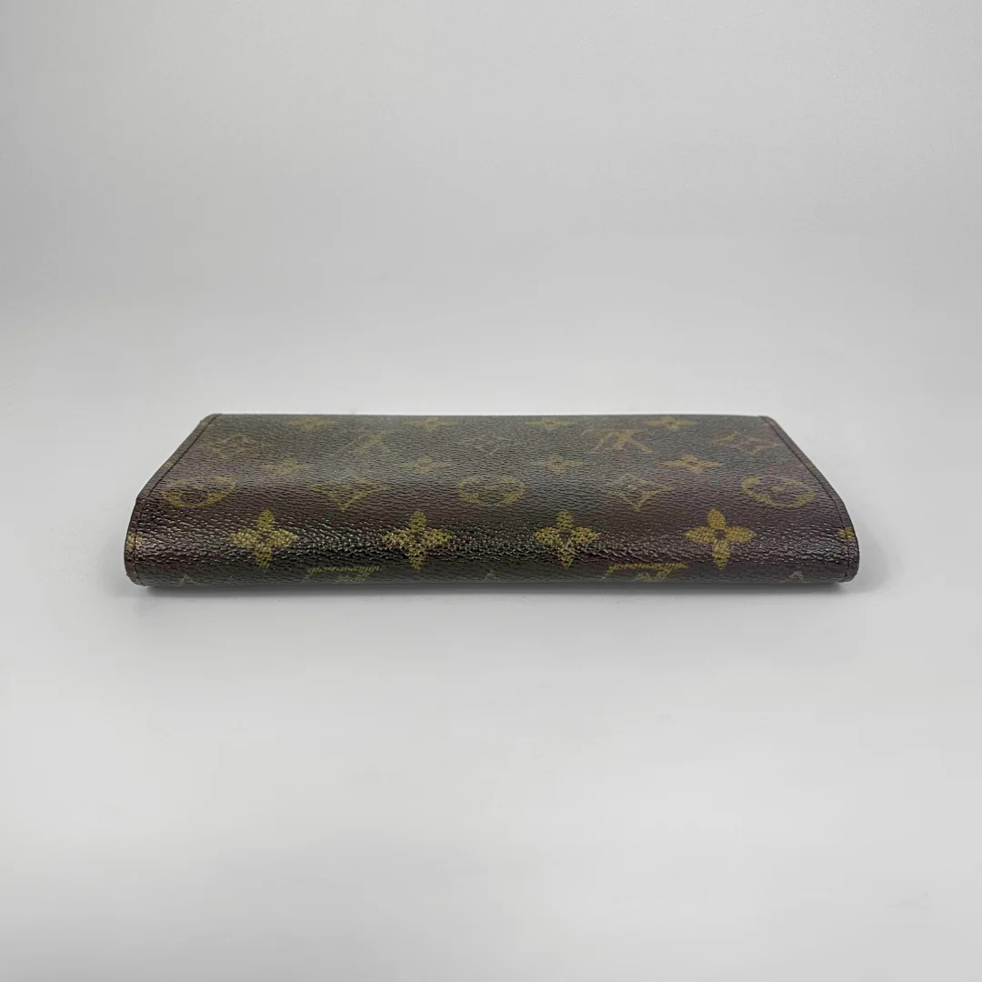 Louis Vuitton monogram clutch bag on a light gray background