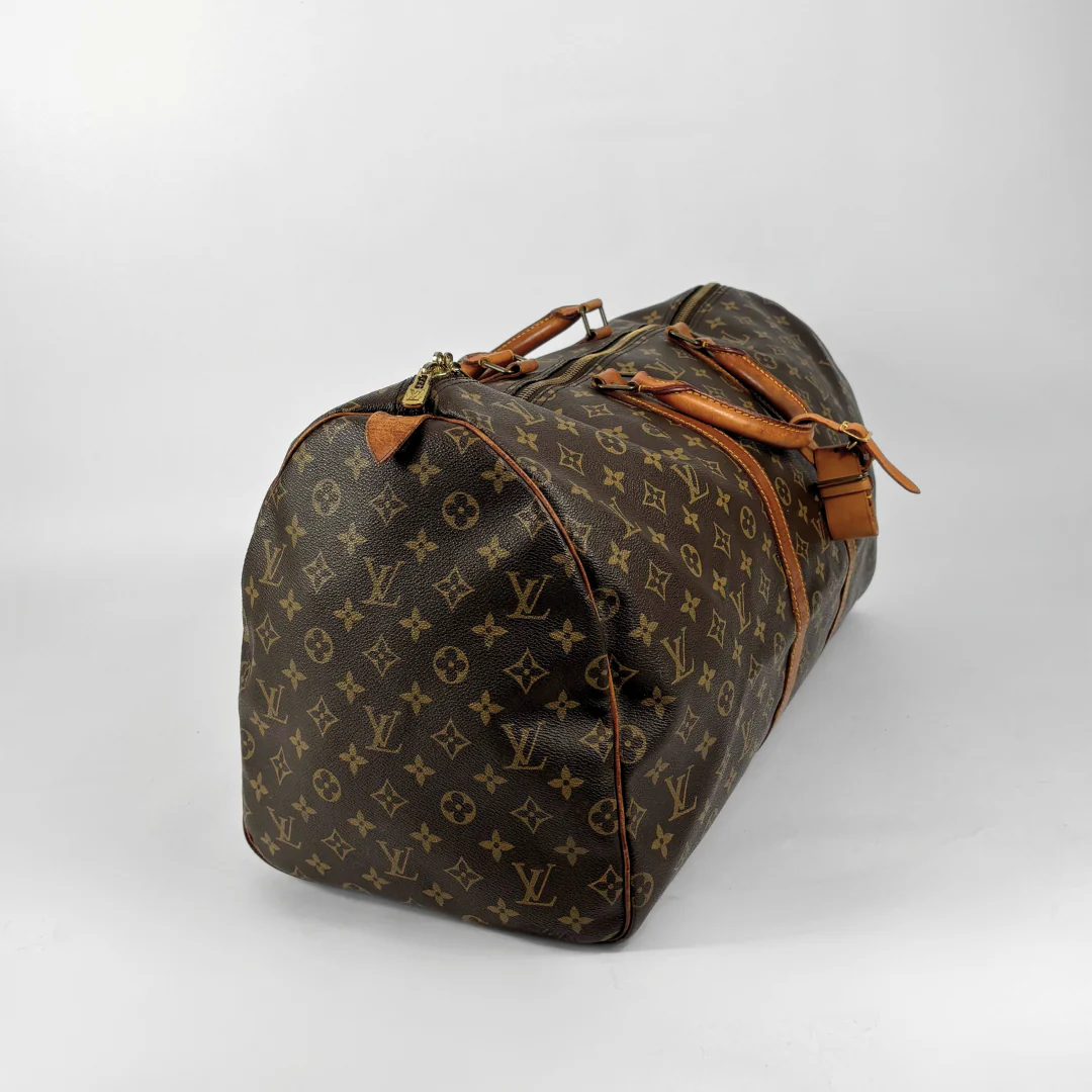 Brown Louis Vuitton travel bag with monogram pattern on a white background