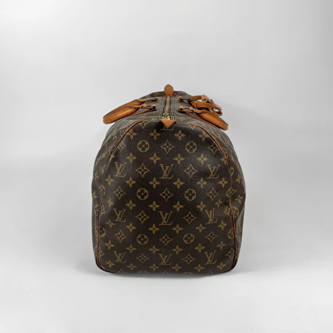Brown Louis Vuitton travel bag with monogram pattern on a white background