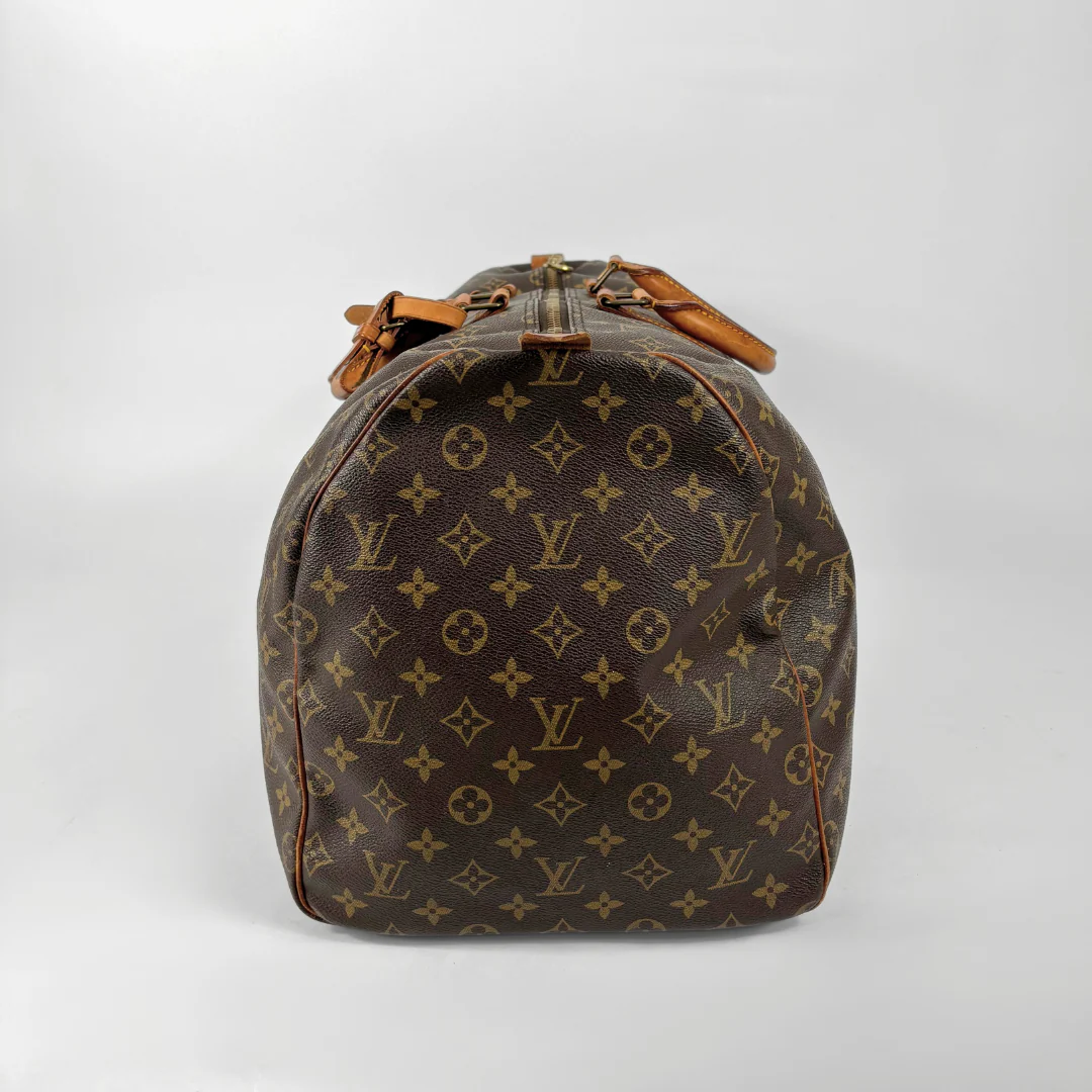 Brown Louis Vuitton travel bag with monogram pattern on a white background