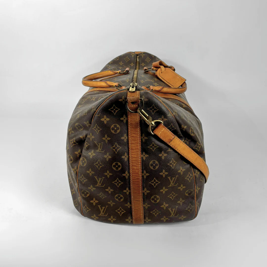 Brown Louis Vuitton travel bag with monogram pattern on a white background