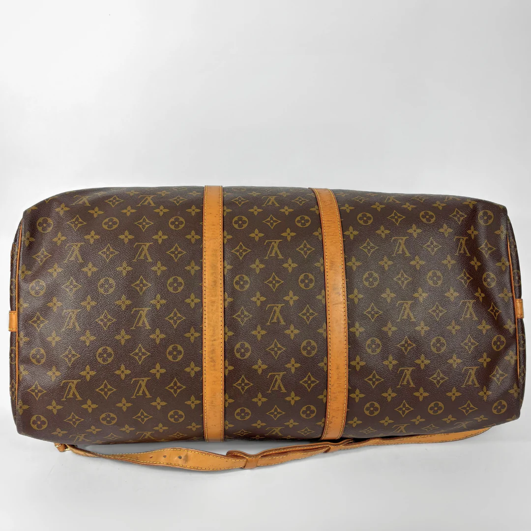 Brown Louis Vuitton travel bag with monogram pattern on a white background