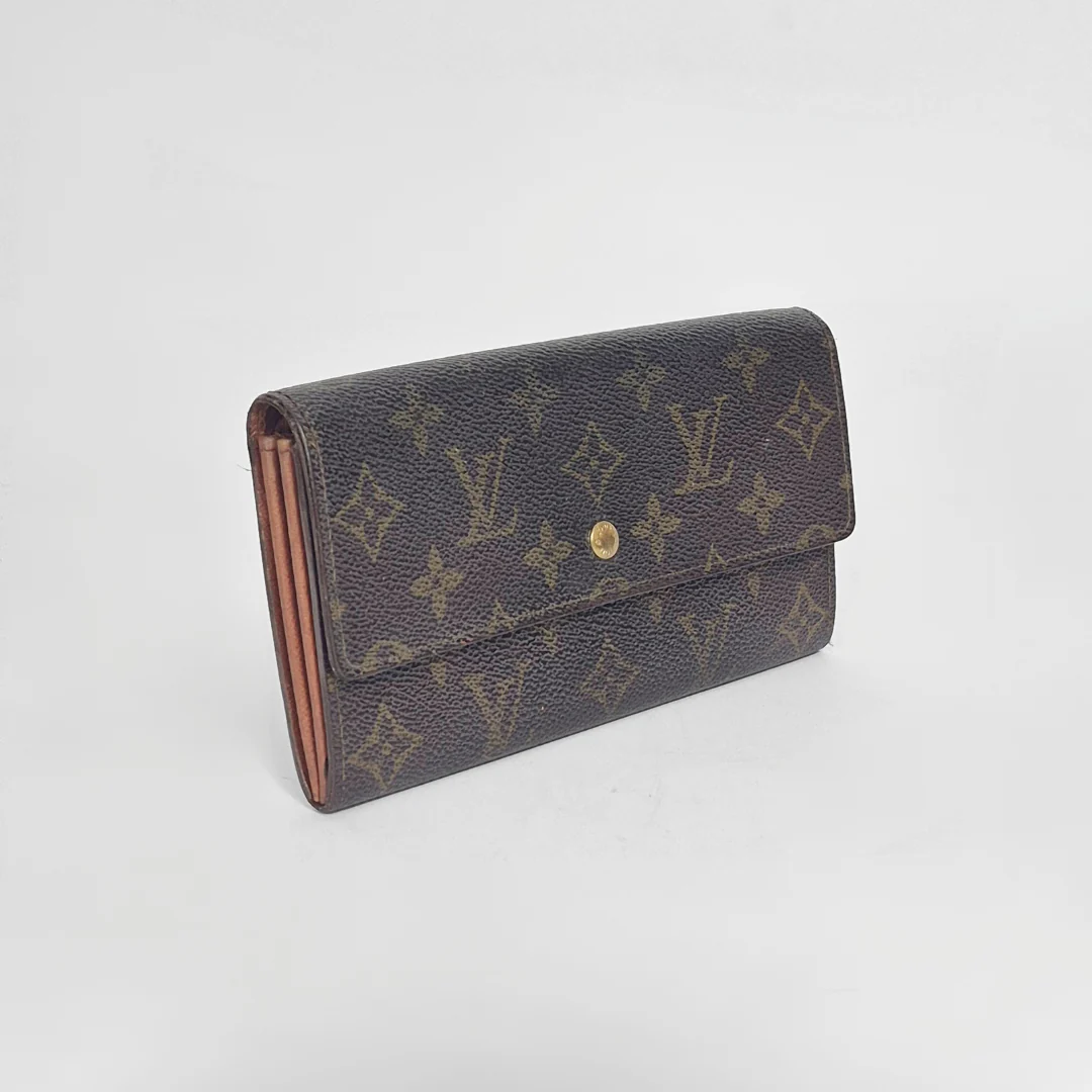 Louis Vuitton wallet with monogram pattern on a white background