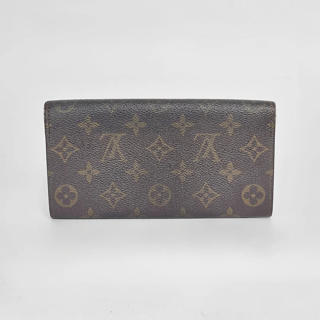 Louis Vuitton wallet with monogram pattern on a white background