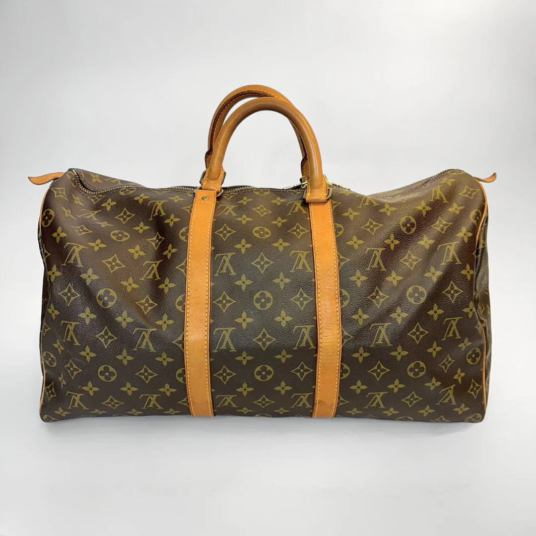 Brown travel bag with tan leather straps on a white background