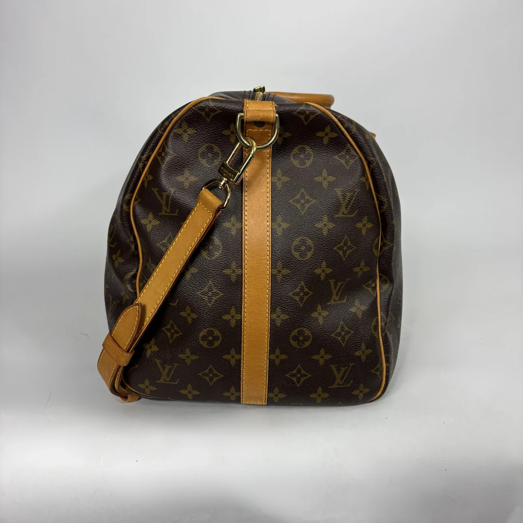 Brown leather duffel bag with tan straps on a white background