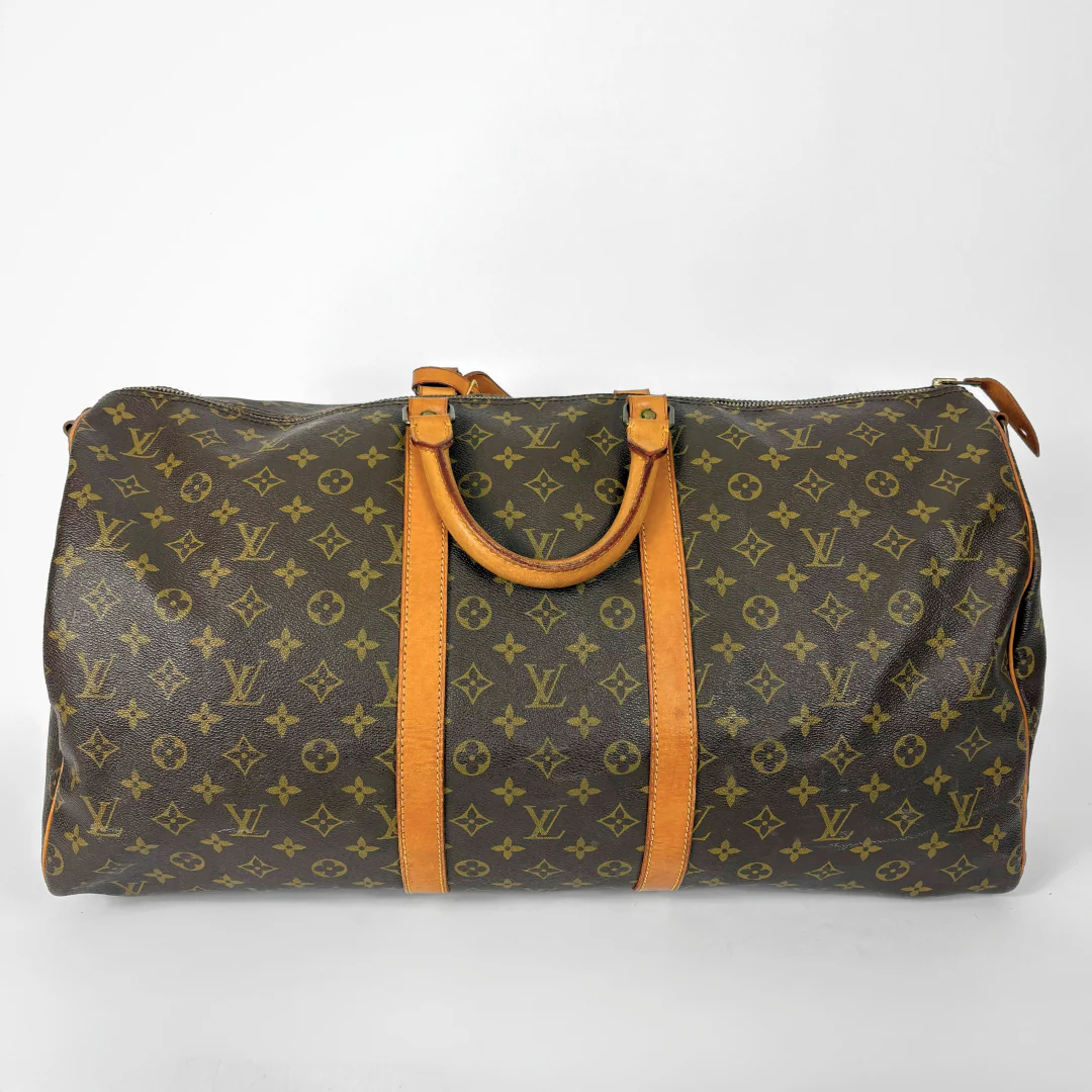 Louis Vuitton monogram travel bag with brown handles on a white background