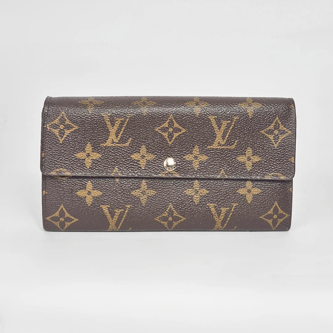 Designer wallet with monogram pattern on a light gray background