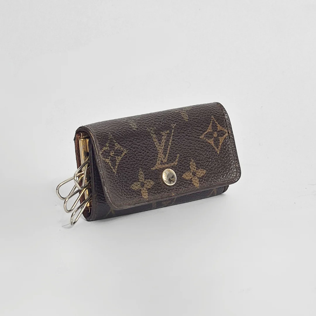 Louis Vuitton wallet with monogram pattern on a light gray background