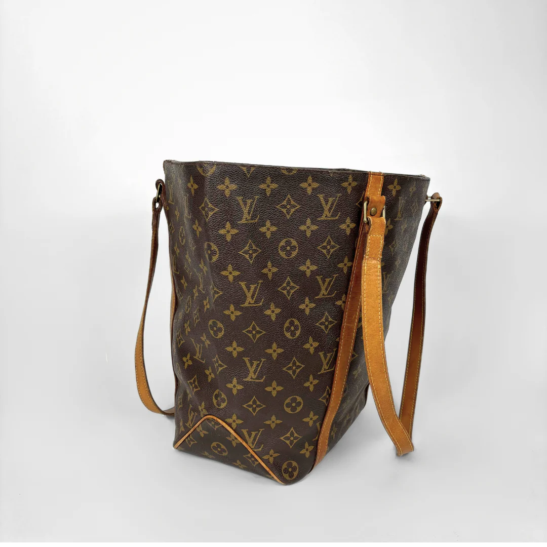 Brown monogram handbag with tan leather accents on a white background