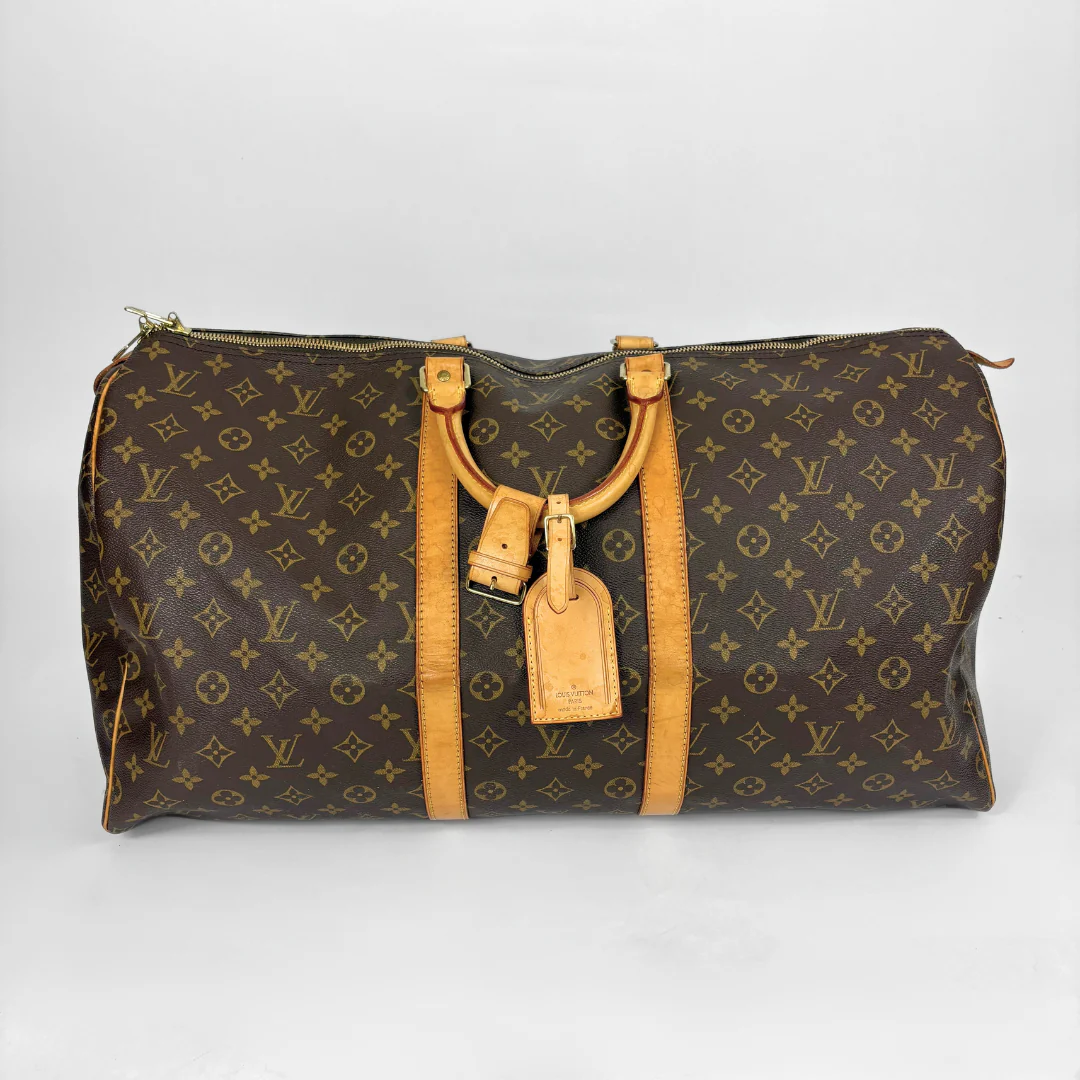 Brown leather bag with gold monogram pattern on a white background