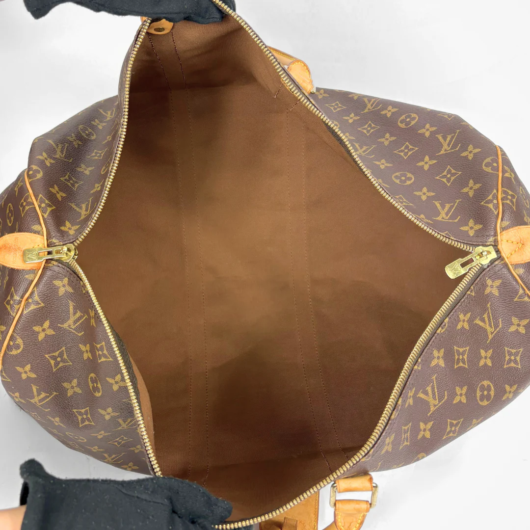 Brown leather bag with gold monogram pattern on a white background