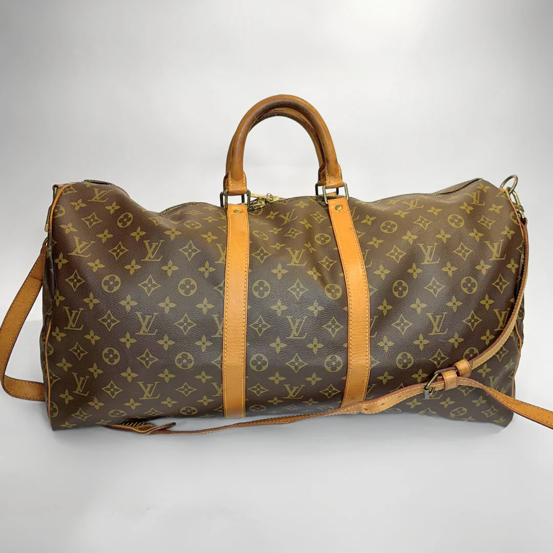 Brown leather duffel bag with tan straps on a white background