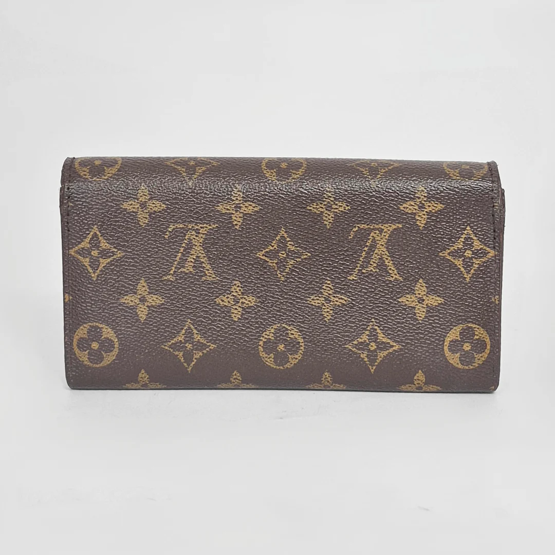 Brown wallet with gold monogram pattern on a white background