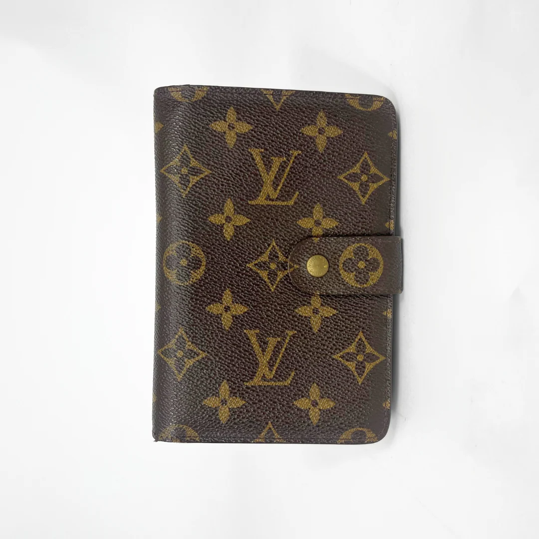 Brown wallet with gold monogram pattern on a white background