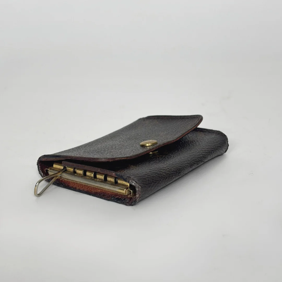 Black leather wallet with gold zipper on a light gray background