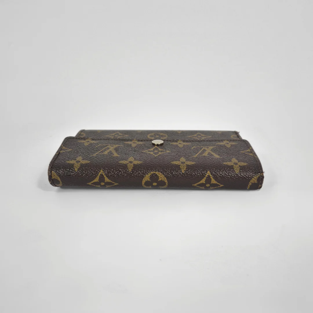 Louis Vuitton wallet with monogram pattern on a white background