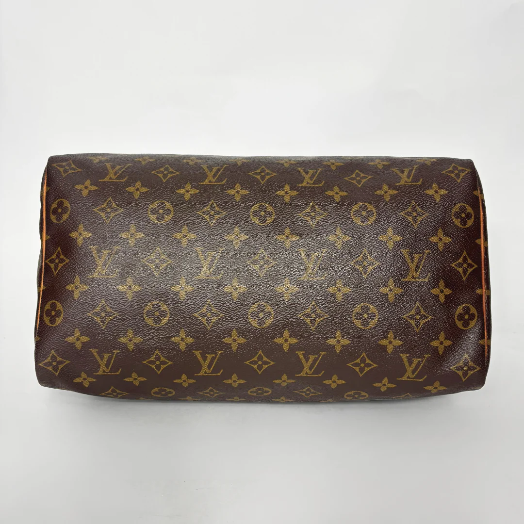 Brown handbag with monogram pattern on a white background