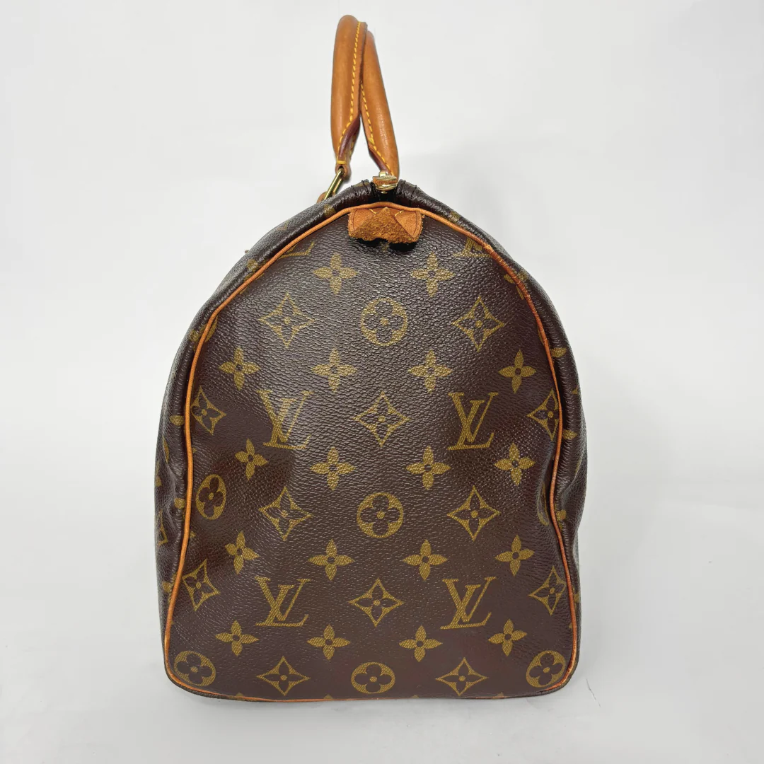 Brown handbag with monogram pattern on a white background