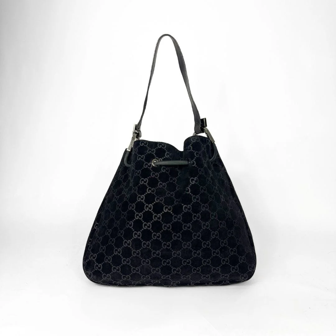 Gucci GG black suede shoulder bag on a white background