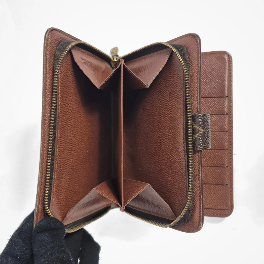 Brown leather wallet with gold zipper on a white background