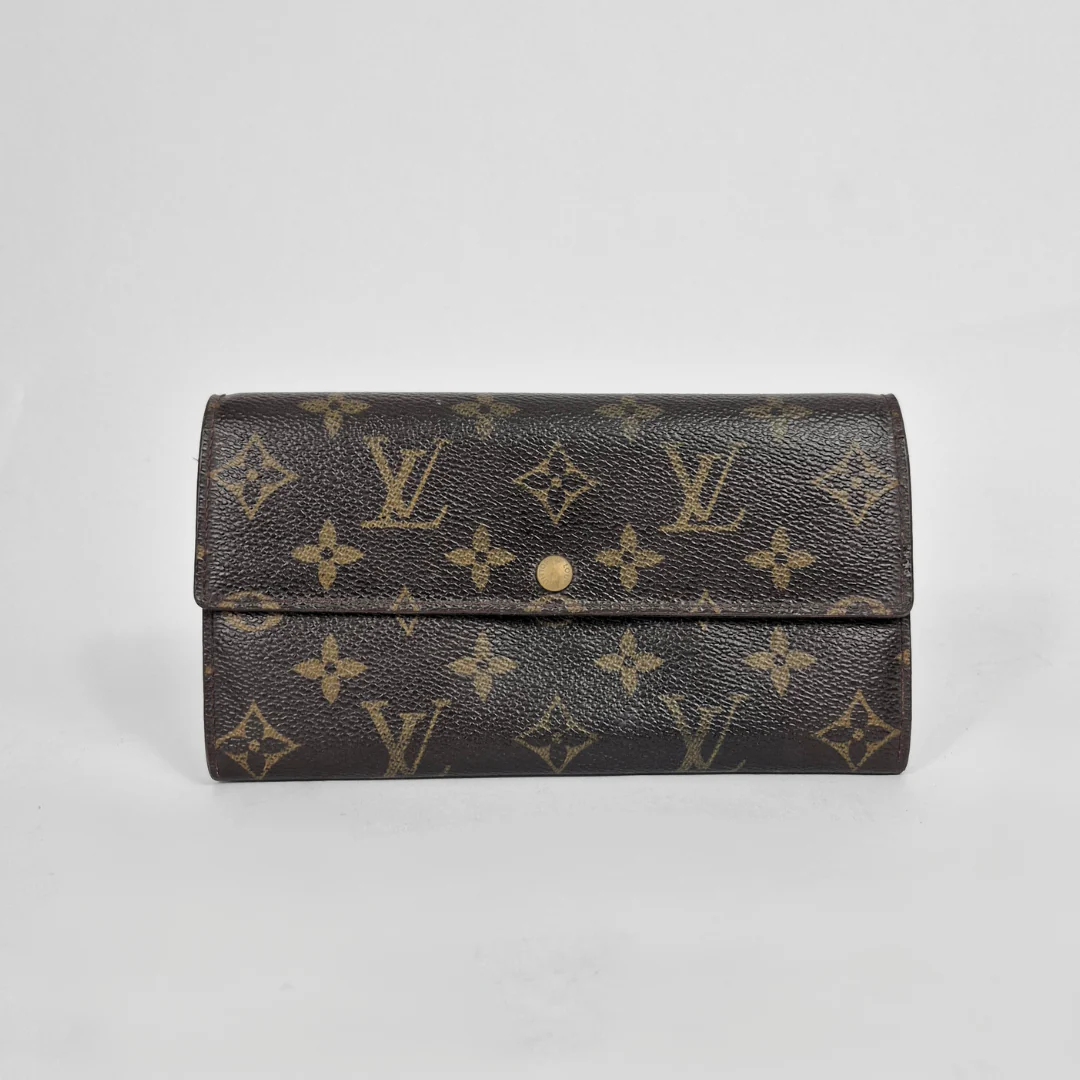Louis Vuitton wallet with monogram pattern on a light gray background